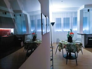 A dining area with two tables, each with a floral tablecloth and a potted plant with red flowers. - ADRY LIVING ART - A Curated Stay in Palermo (Palermo)