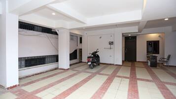 A spacious indoor area with a tiled floor, a motorcycle, and a door leading to another room.