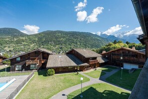 A wooden chalet with a swimming pool, surrounded by a well-maintained lawn and a mountainous backdrop. - Geret - Duplex for 6 People | Fireplace | Near the Slopes | Views (Saint-Gervais-les-Bains)