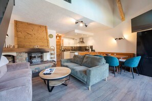 Un salon moderne avec une cheminée, un canapé et un coin repas.