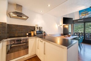 A modern kitchen with a stainless steel range hood, a microwave, and a coffee maker on the counter. - Geret - Duplex for 6 People | Fireplace | Near the Slopes | Views (Saint-Gervais-les-Bains)