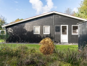 A single-story building with a dark exterior, a white door, and three windows. - "Ømunde" - 2.5km from the sea by Interhome (Blokhus)