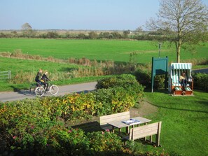 A pathway with a bench and a picnic table, surrounded by greenery and flowers. - Holiday Apartment With 2 Bedrooms (Wrixum)