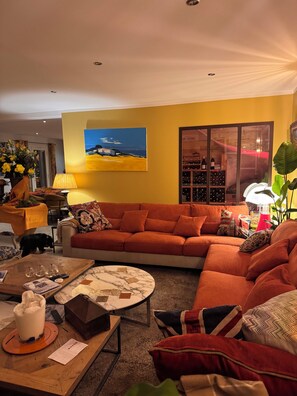 A living room with a sofa, a coffee table, and a wine rack. - Une Bastide en Provence (Plan-d'Orgon)