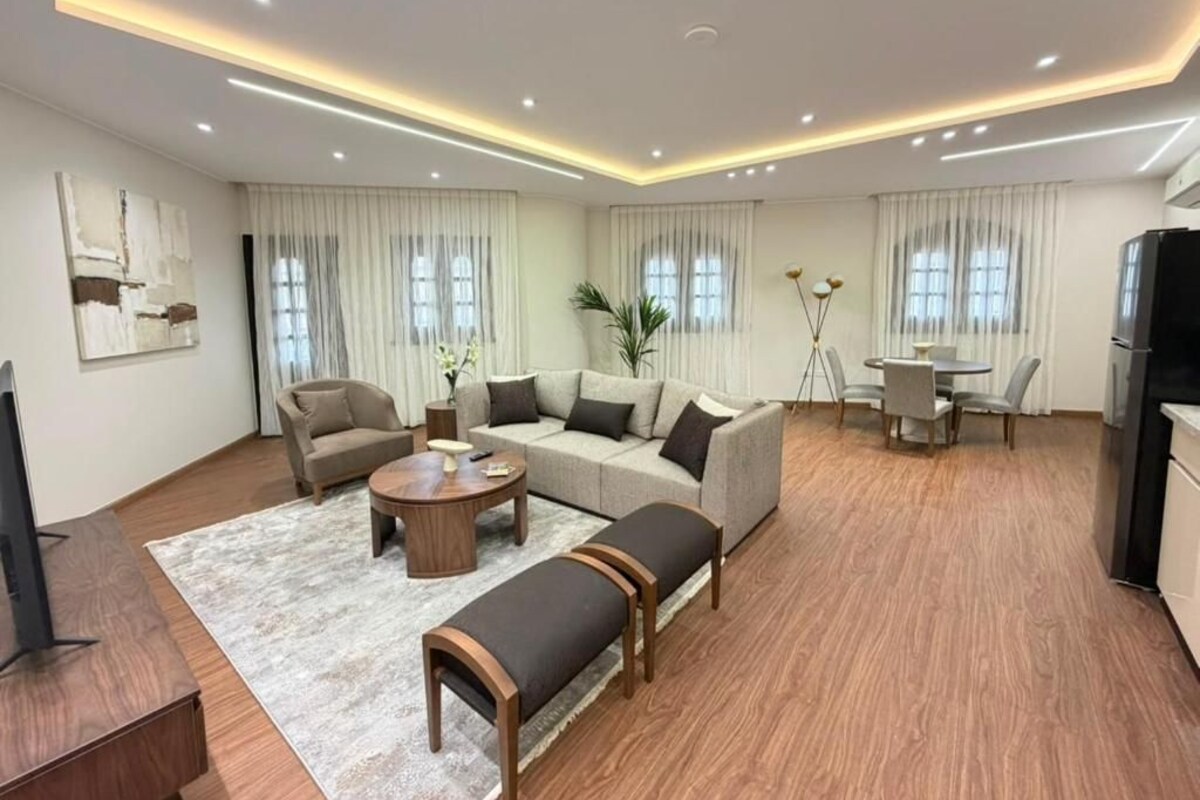 A spacious living room with a sofa set, a coffee table, and a television.