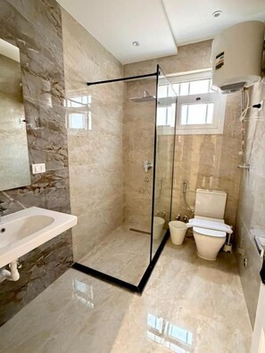 A modern bathroom with a glass-enclosed shower, a toilet, and a sink. - Vesta - New Cairo Residence  (new cairo)