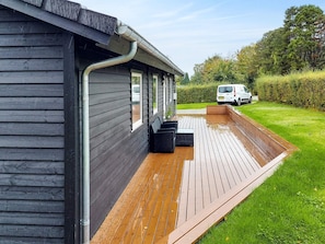 A wooden deck adjacent to a building with a metal gutter system. - 6 Person Holiday Home in Melby (Melby)