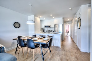 A modern kitchen with white cabinets, a stainless steel refrigerator, and a microwave. - Elegant 3BR Condo for Families | 2 Baths, AC & Fast WiFi (Montréal)