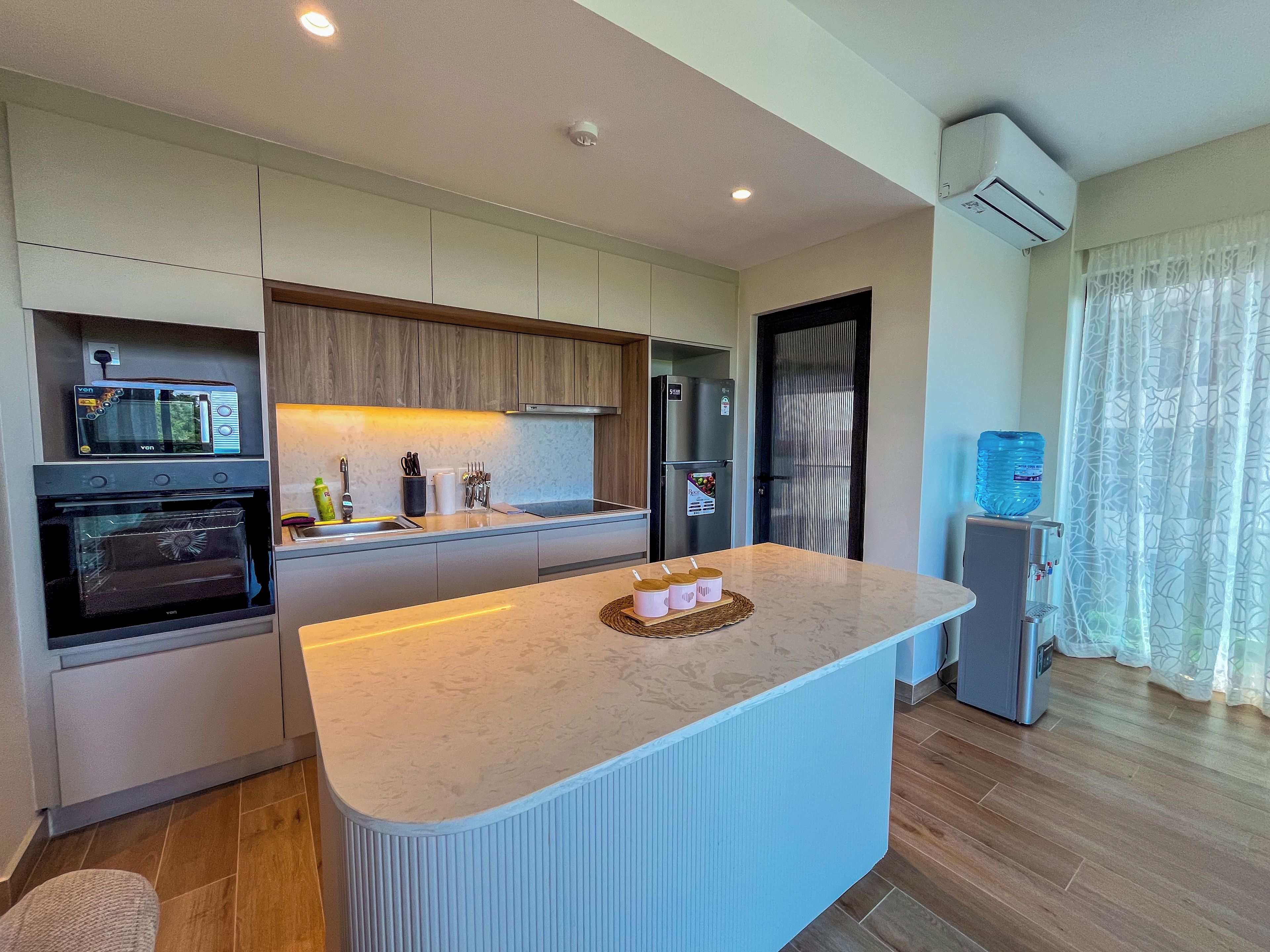 Een moderne keuken met inbouwapparatuur, een centraal eiland en een waterdispenser.