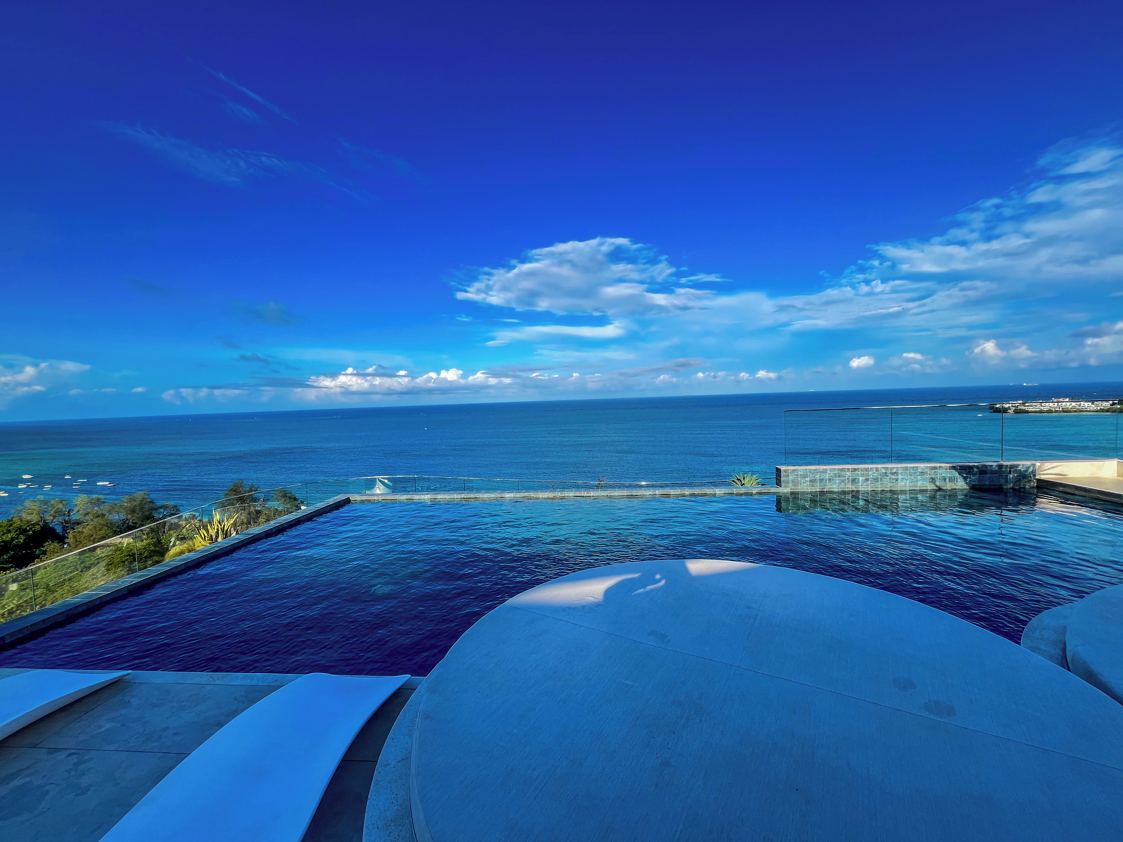 A swimming pool with a view of the ocean and a distant island.