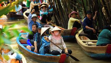 A group of people in traditional boats on a river.