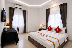 A hotel room with a bed, a desk, a chair, a TV, and an air conditioning unit. - The Rice Hotel 121 Bui Vien (Ho Chi Minh City)