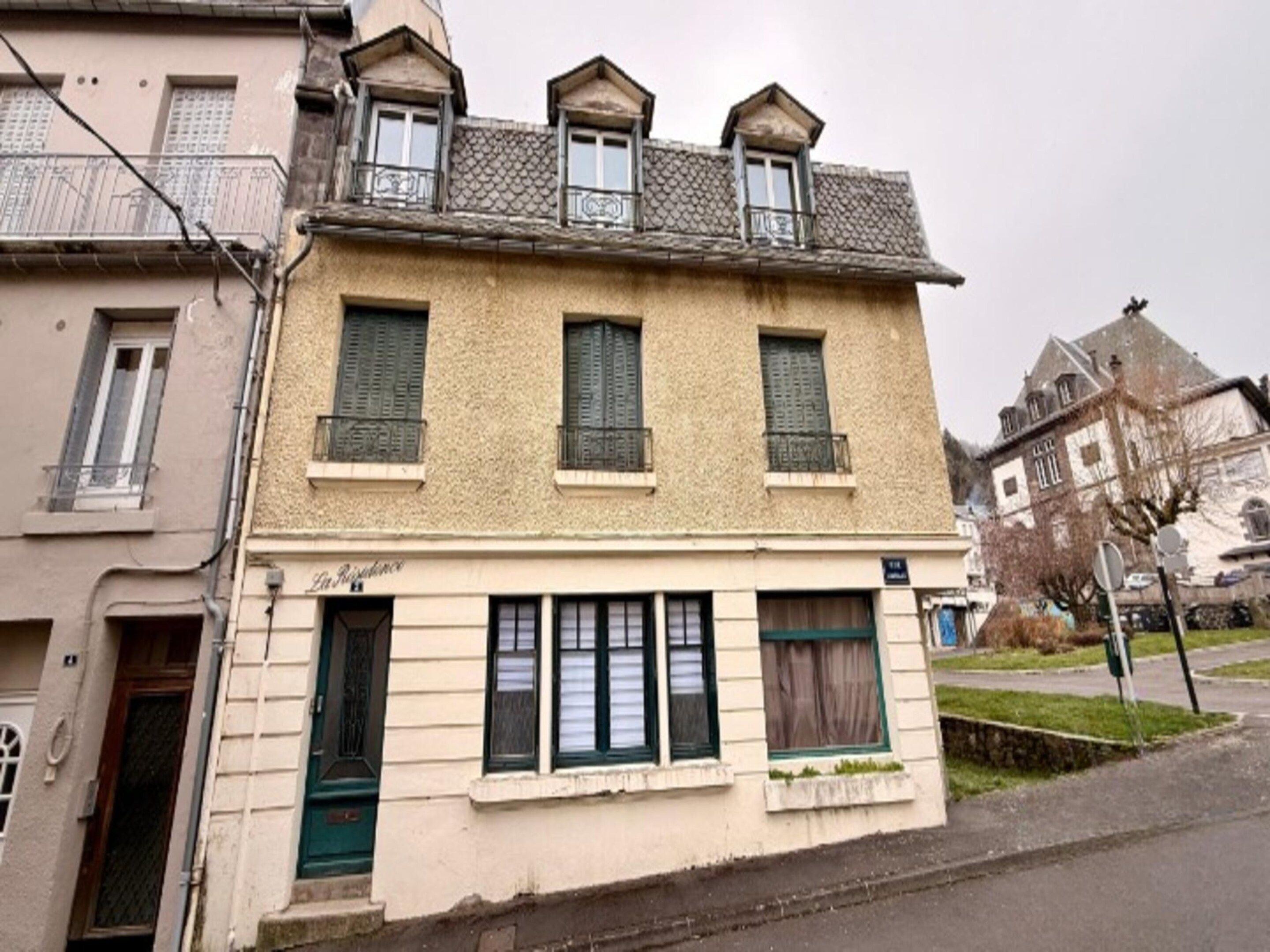 A two-story building with a balcony on the upper floor and a ground-floor entrance.