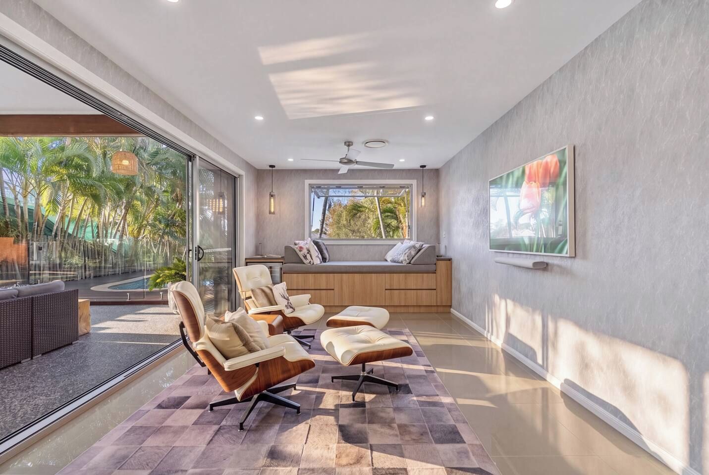 A modern living room with a large window, a sofa, and a TV.