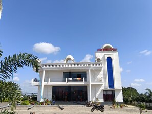 A white building with a blue door and a red sign on top. - Wishotel Resort Rajkumari Hridya Palace  (Padri Gajarat)