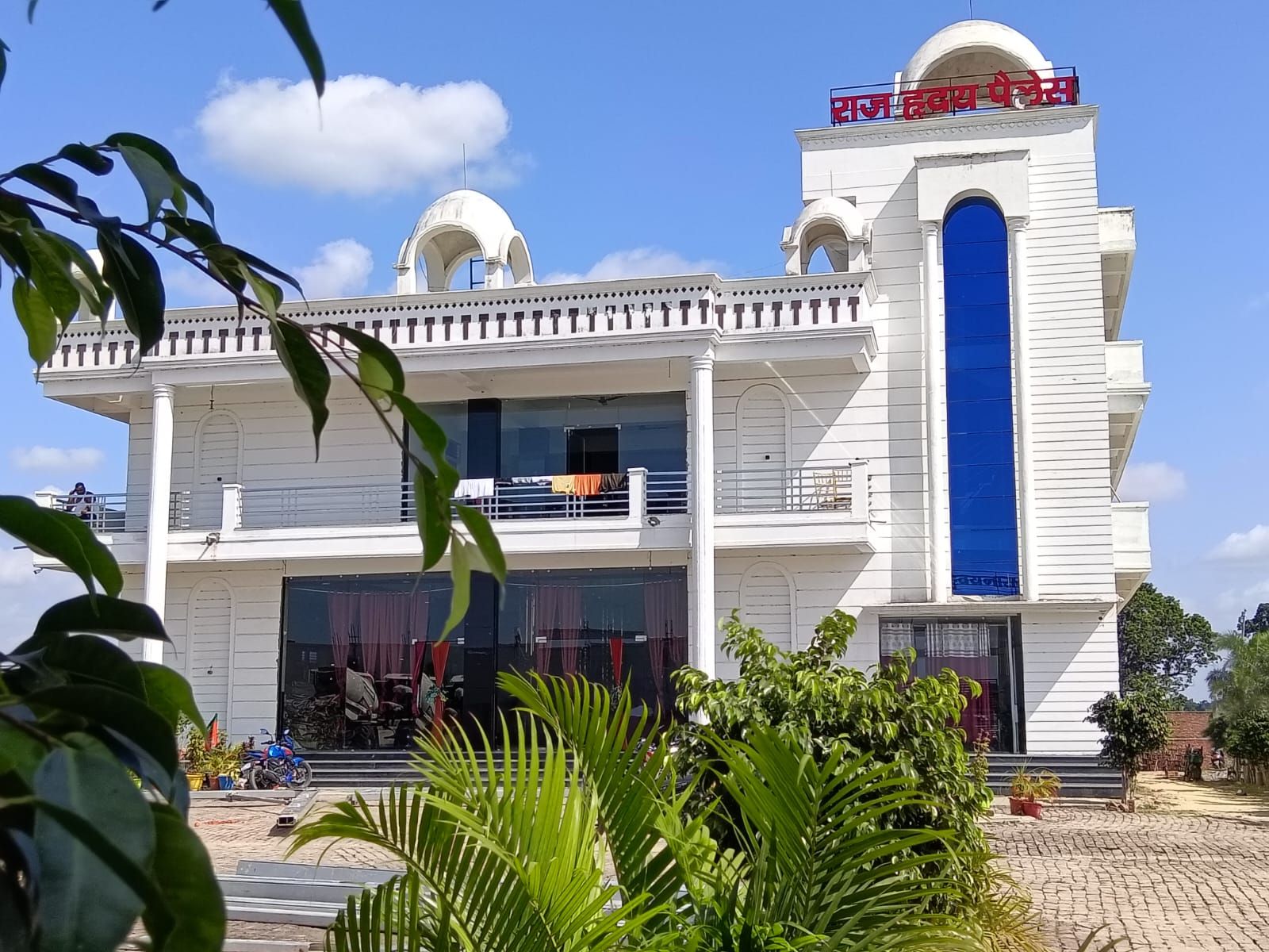 A two-story building with a prominent blue entrance and a sign in a foreign script.
