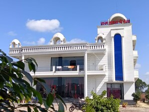 A two-story building with a prominent central tower, large windows, and a flat roof. - Wishotel Resort Rajkumari Hridya Palace  (Padri Gajarat)