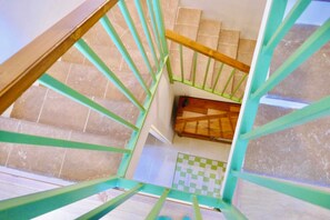 A staircase with a wooden handrail and green metal balusters. - Cosy Asturian home 10 minutes from Rodiles & Villaviciosa - pet friendly! (Villaviciosa)