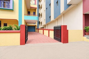 A multi-story residential building with a central corridor leading to a gated entrance. - Deluxe The Golden Sunrise (Danapur)