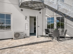 A patio area with a table and chairs, a Panasonic air conditioning unit, and a staircase. - "Apsolon" - 50m to the fjord by Interhome (Tarm)