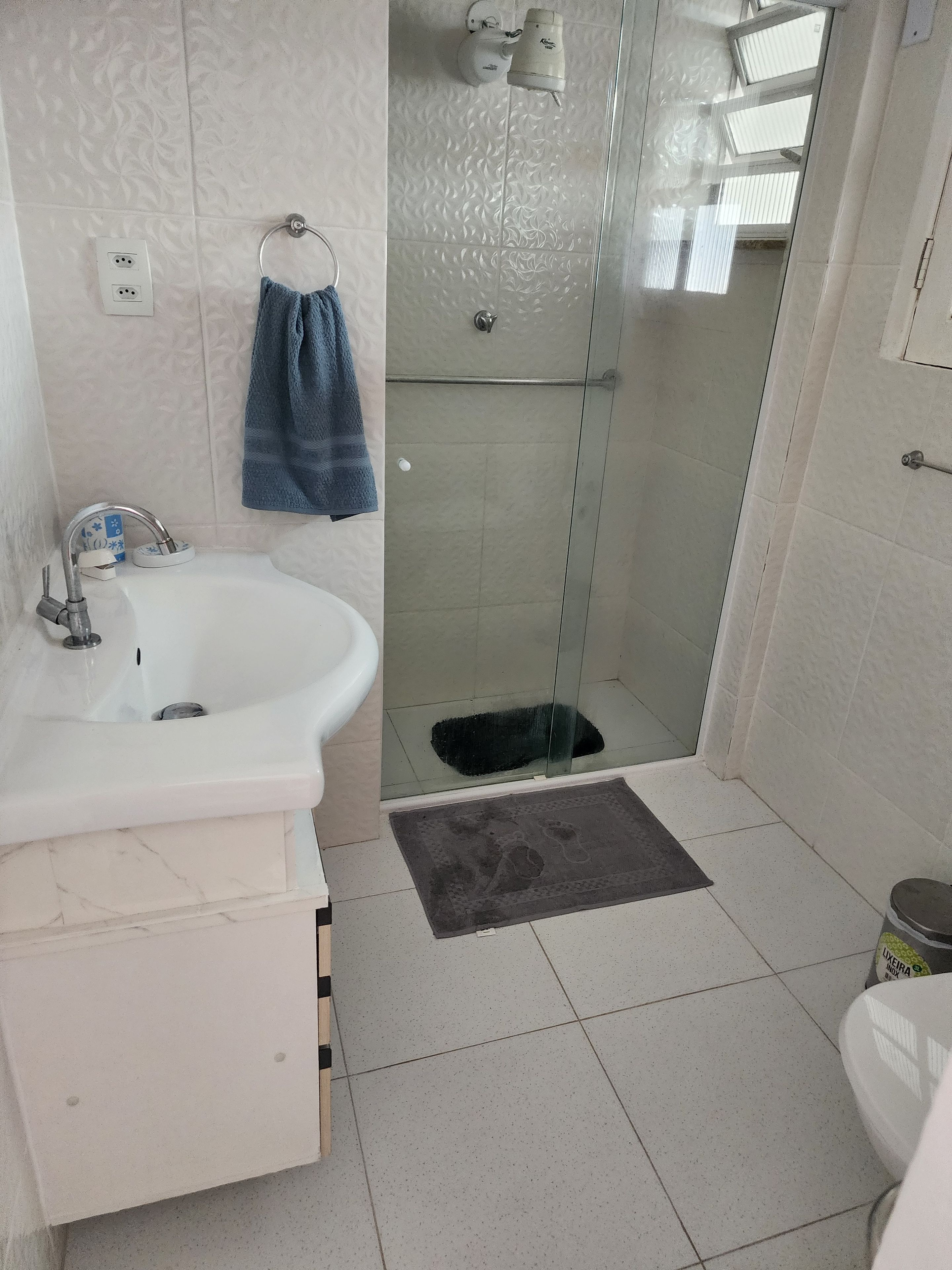 A bathroom with a white sink, a glass shower enclosure, and a toilet.