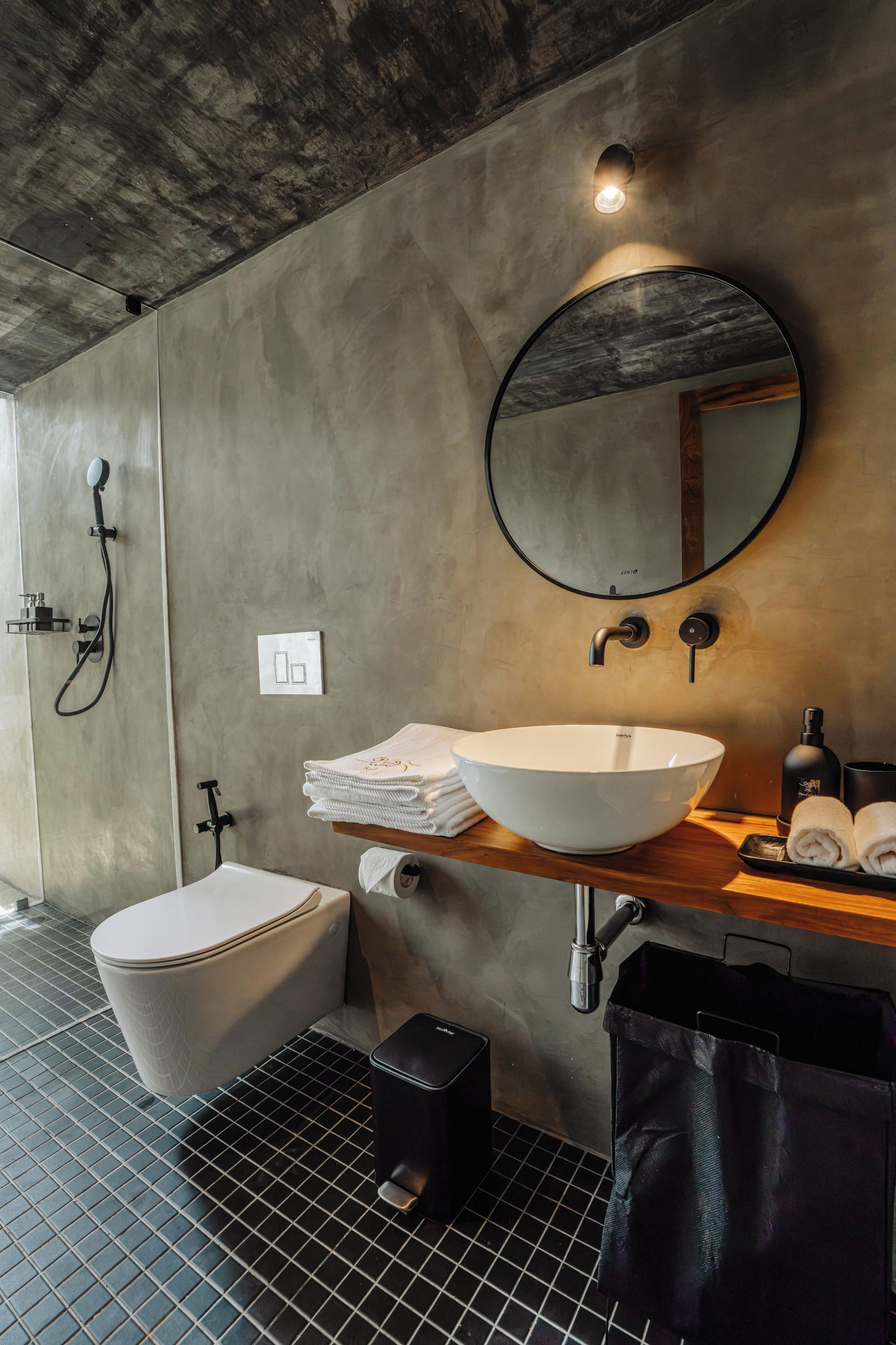 Un baño moderno con inodoro, bidé, lavamanos y espejo.