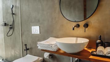 Un baño moderno con inodoro, bidé, lavamanos y espejo.