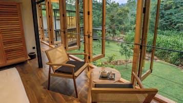 Un balcón de madera con vistas a un jardín exuberante.