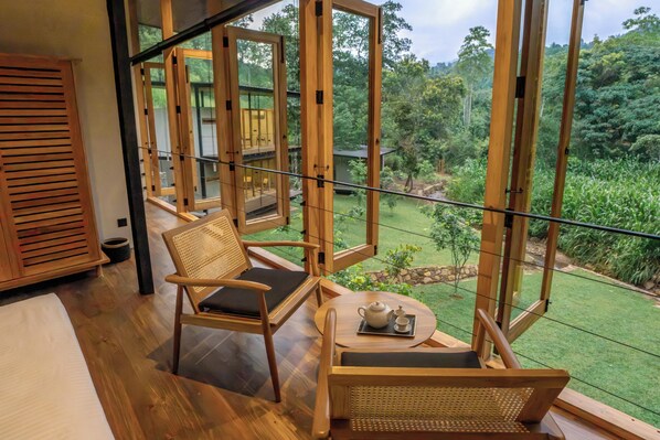 Un balcón de madera con vistas a un jardín exuberante.