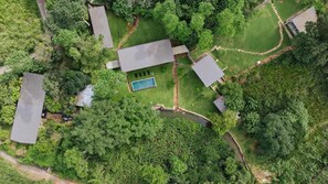 Vista aérea de una zona residencial con varias casas, una piscina y un pequeño estanque.