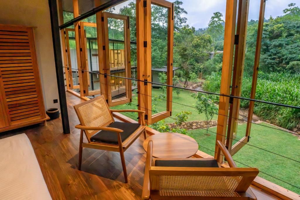 Una habitación con un ventanal grande, muebles de madera y vistas a un jardín.