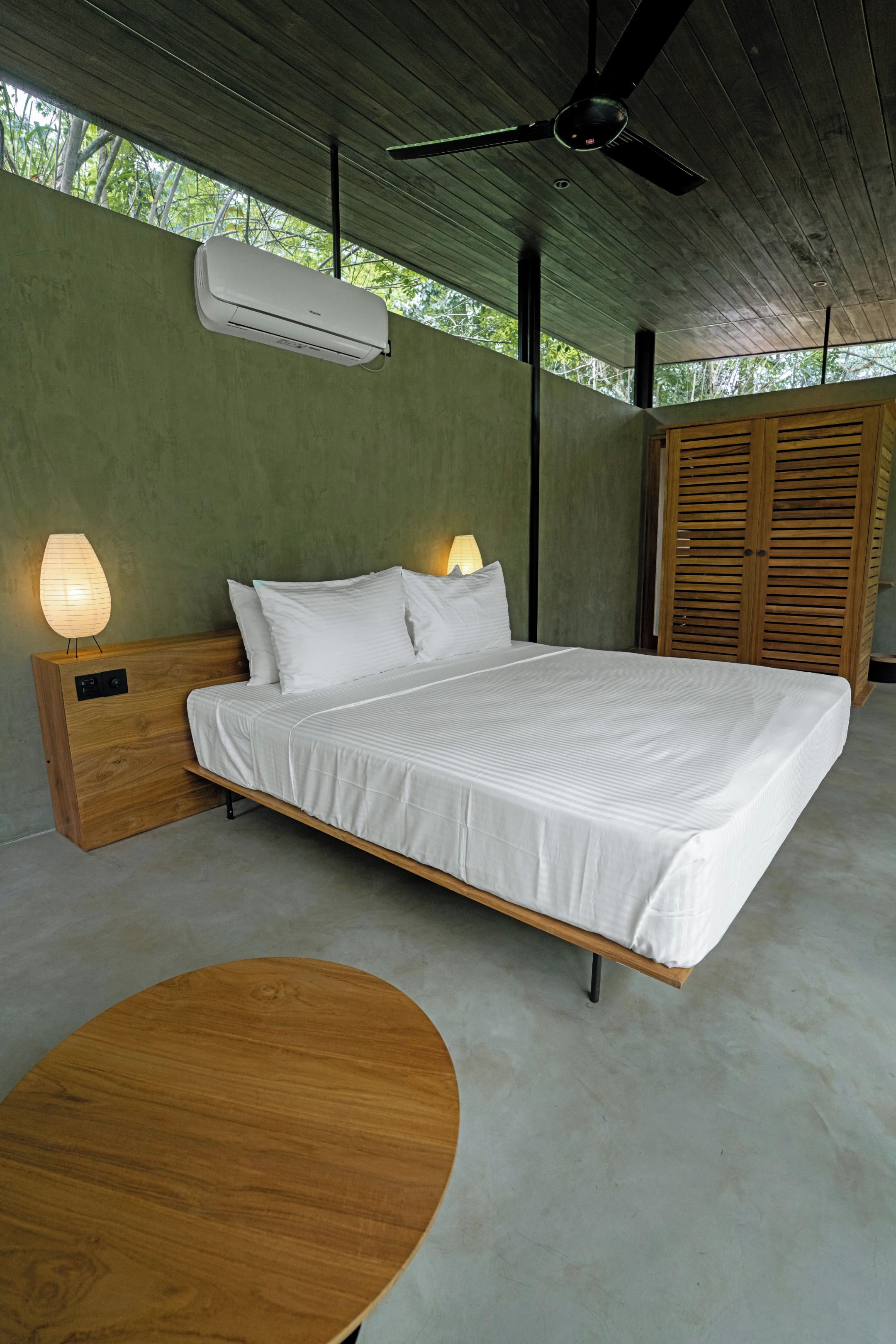 Un dormitorio con cama, lámparas de noche, ventilador de techo y aire acondicionado.