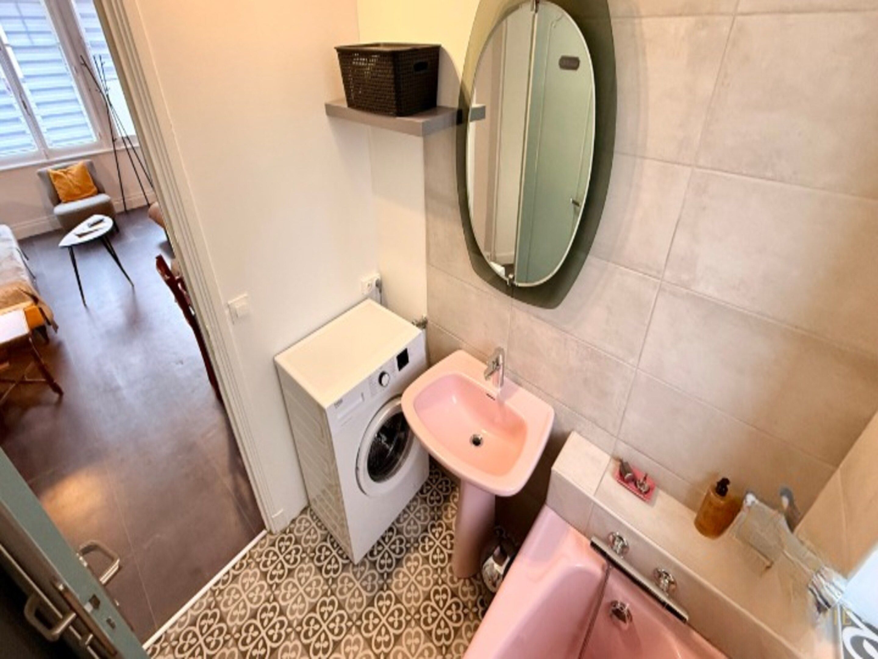 A compact bathroom with a washing machine, a sink, and a bathtub.
