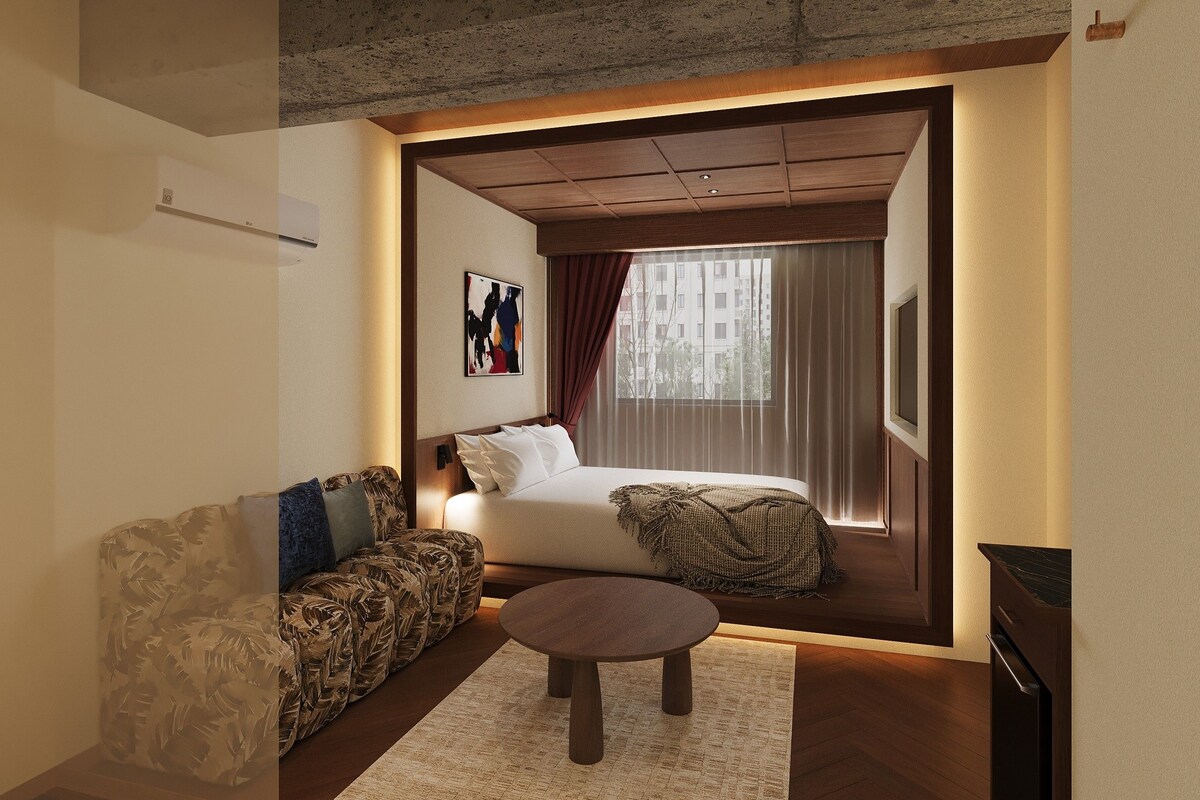 Une chambre d’hôtel avec un lit, un canapé, une table basse et un téléviseur.