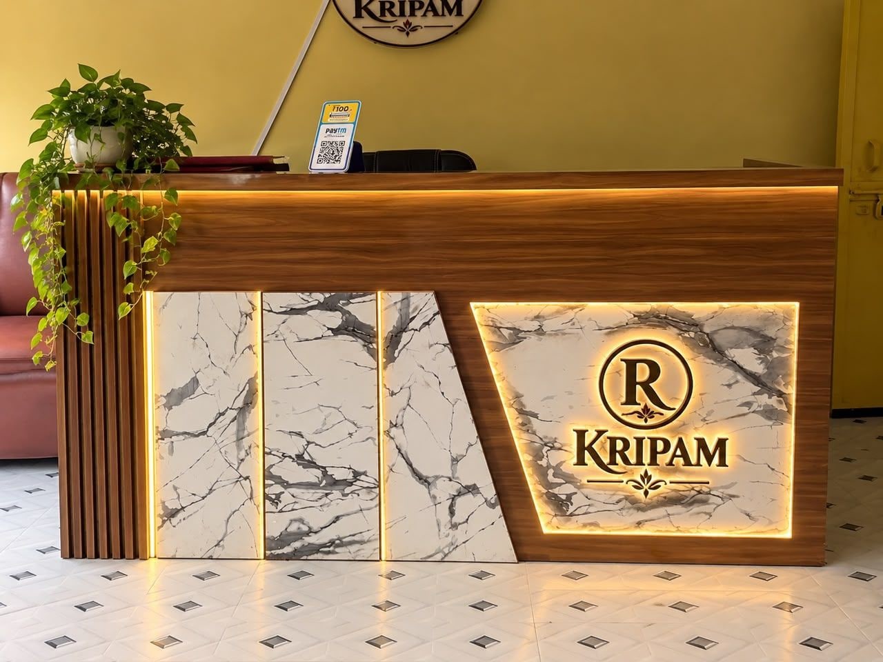 A reception desk with a marble design, a logo, and a QR code for Kripam.
