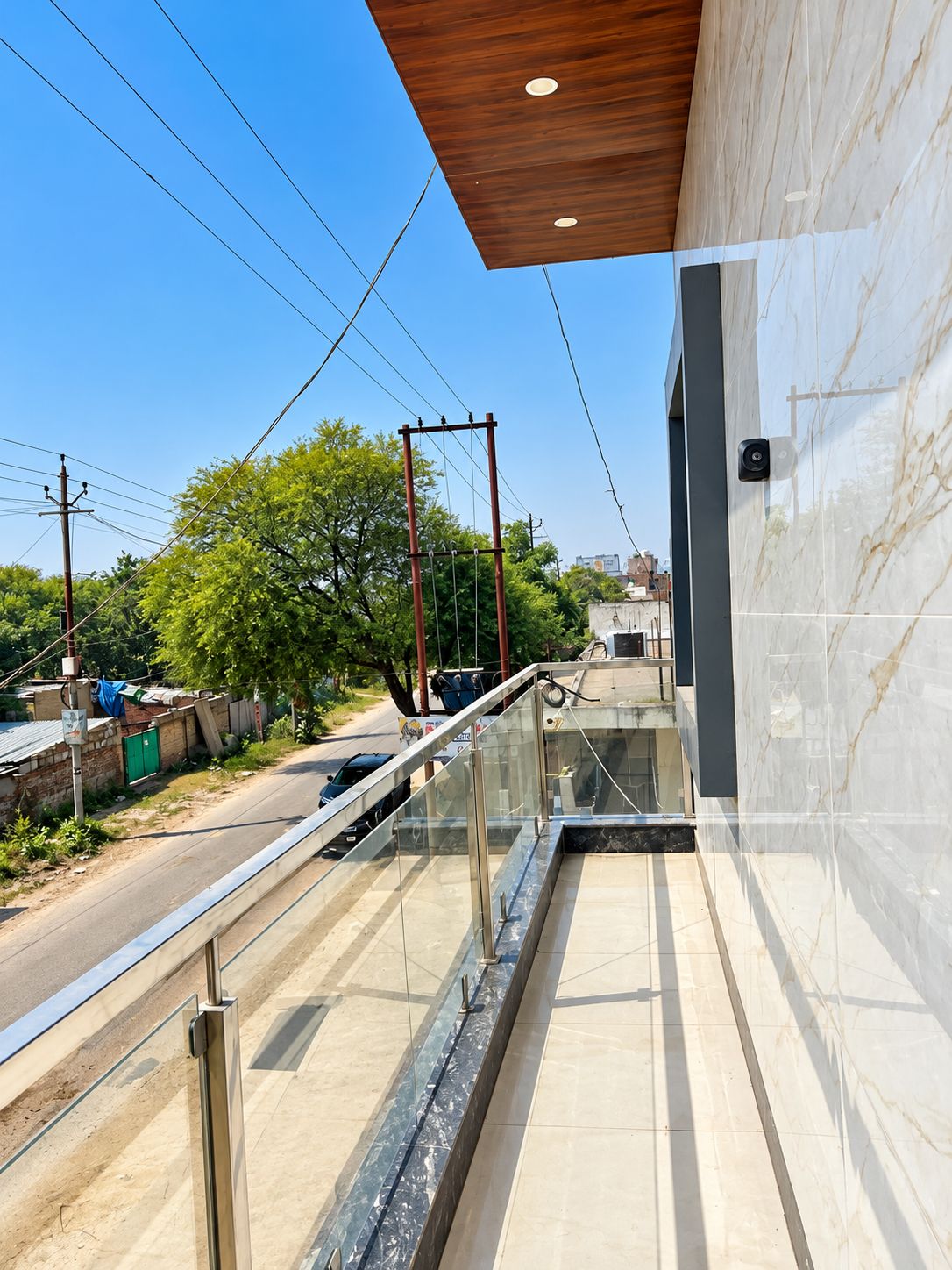 A modern building with a glass balcony overlooking a street.