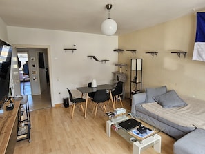 A modern living room with a sofa, coffee table, and a dining area with chairs and a table. - Cozy apartment in the heart of Essen's Rüttenscheid neighborhood (Essen)