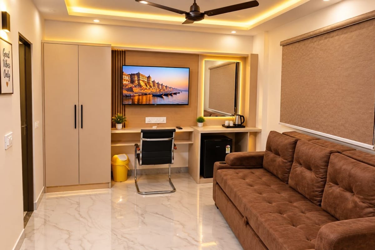 A modern living room with a sofa, a television, and a ceiling fan.