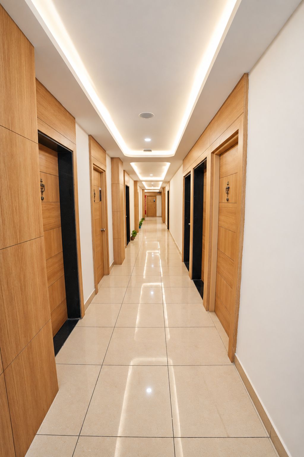 A hotel hallway with wooden doors, a tiled floor, and recessed lighting.