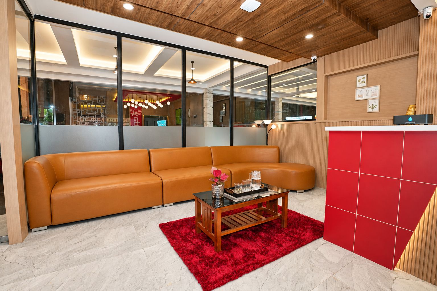 A modern living room with a leather sofa, a wooden coffee table, and a red rug.