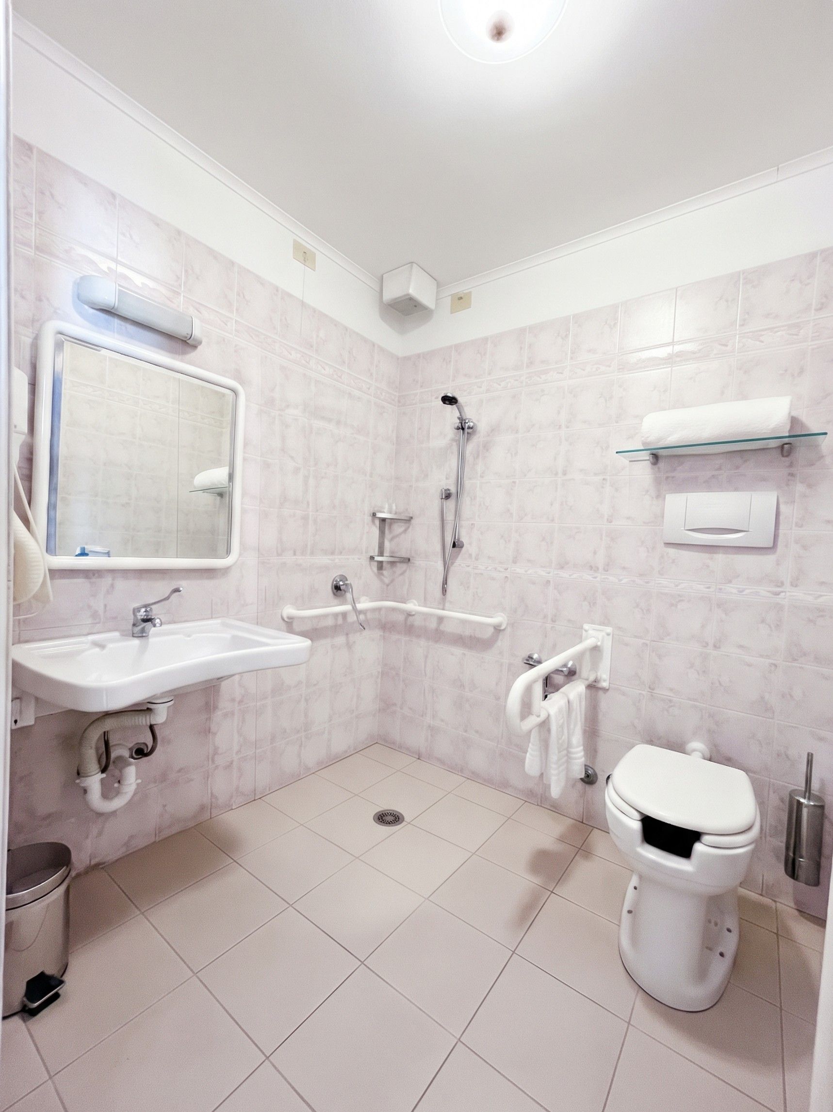 Un baño con lavamanos, inodoro y ducha.