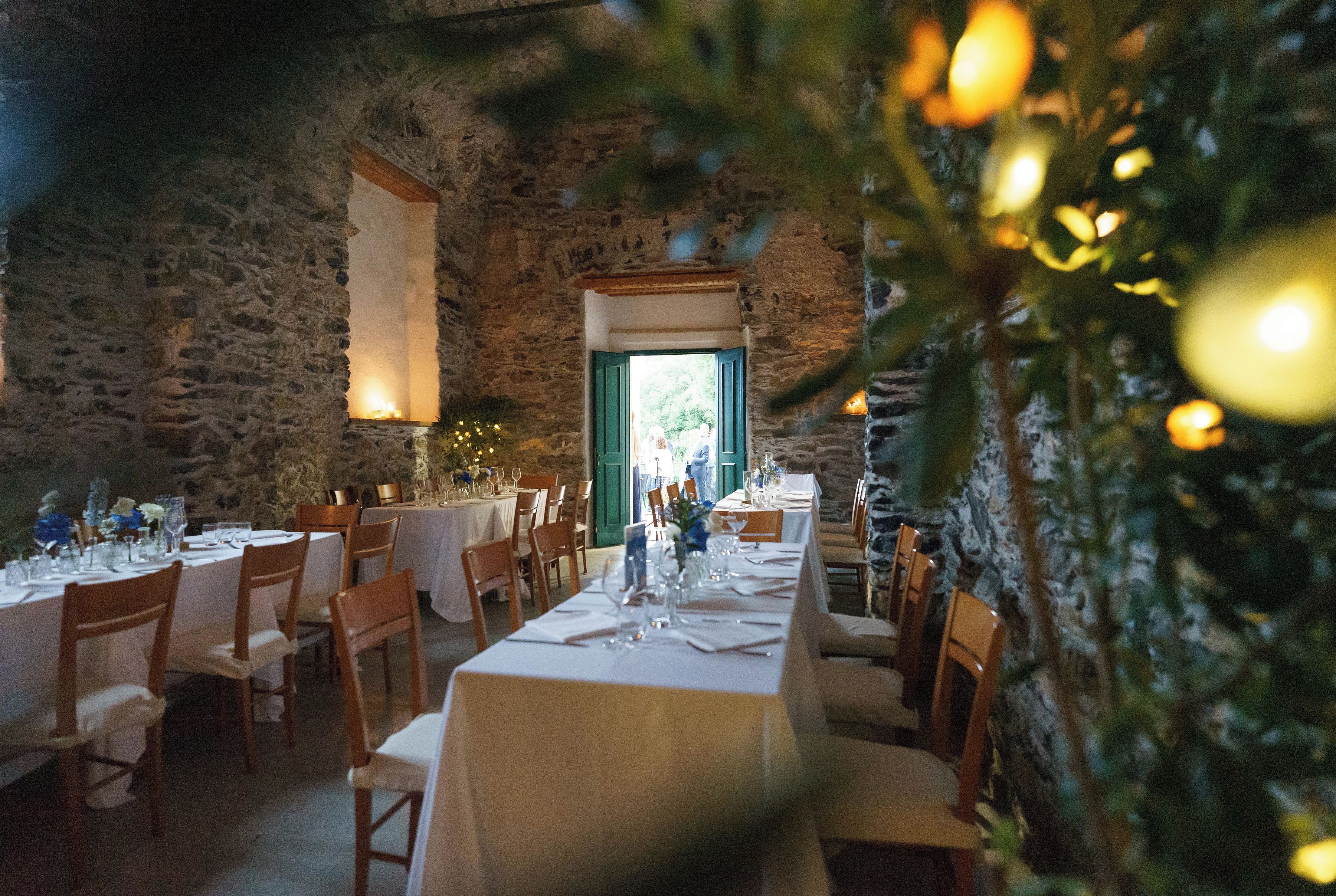 Un restaurante con paredes de piedra, mesas y sillas de madera.