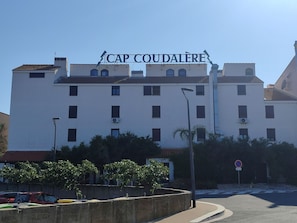 Un edifici de diversos pisos amb un rètol a la part superior que diu 'CAP COUDALERE'.