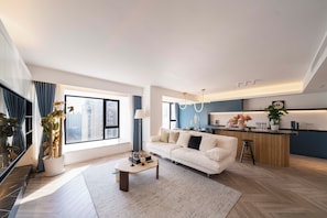 A modern living room with a sofa, coffee table, and a view of the city through large windows. - Book&Bed-The Bund People's Square 3 (Huangpu District)
