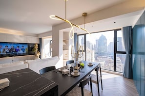 A modern dining area with a dark marble table, chairs, and a city view through large windows. - Book&Bed-The Bund People's Square 3 (Huangpu District)