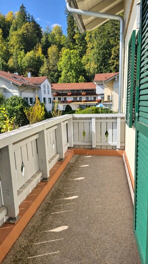 Un balcón con vista a casas y árboles vecinos.