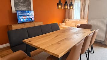 Ein stilvoller Essbereich mit einem Holztisch, Ledersesseln und Pendelleuchten.