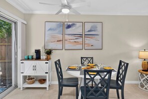 A dining area with a round table, black chairs, and a ceiling fan. - Ground Floor, Patio, Siesta Key, Beach Gear (Sarasota)