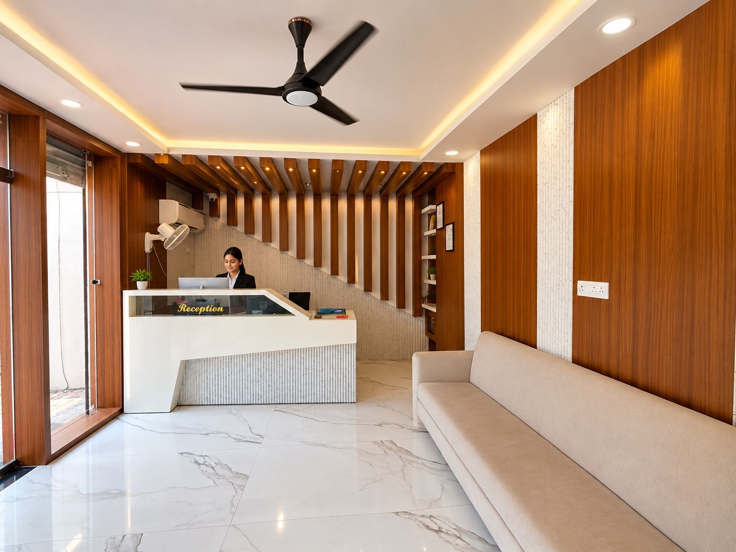 Zona de recepción con mostrador, ventilador de techo, escalera y sofá.