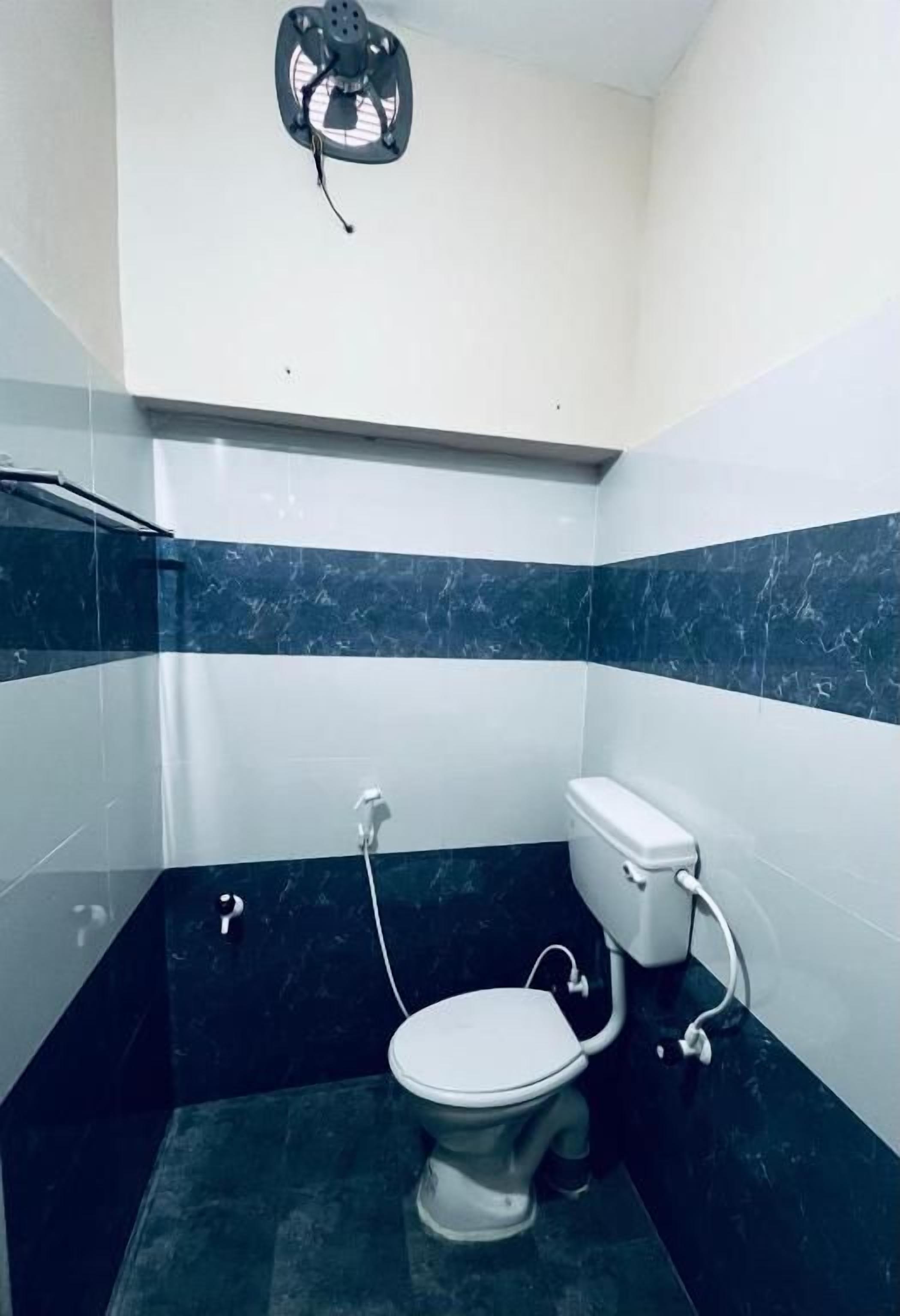 Un baño con inodoro, ducha y ventilador de techo.